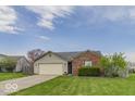 Charming single-story home with a brick facade, attached garage, and beautifully landscaped lawn at 5634 Wynridge Ct, Indianapolis, IN 46235
