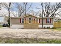 A single-story home with a wooden porch and red shutters on the windows, showcasing its curb appeal at 611 Victor Pl, Shelbyville, IN 46176