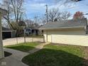 A detached garage on a sunny lot is accessible via a concrete path and offers extra storage at 6186 Ralston Ave, Indianapolis, IN 46220