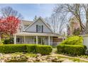 Inviting exterior with a manicured lawn, pond, mature landscaping, and covered front porch at 7124 Purdy St, Indianapolis, IN 46268