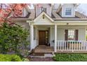 Inviting front porch with wood floors, white railings, traditional pillars, and wooden front door at 7124 Purdy St, Indianapolis, IN 46268