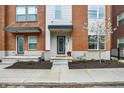 Inviting townhome entrance with a wreath, potted plants, and a well-kept garden bed at 741 Bates St, Indianapolis, IN 46202