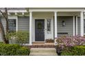 Inviting front door with a wreath and blooming flowers, adding curb appeal to the home at 7613 W Stonegate Dr, Zionsville, IN 46077