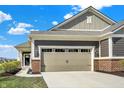 Spacious two-car garage with carriage-style doors and brick accents complementing the home's facade at 8570 Hudson Way, Brownsburg, IN 46112