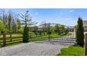 Ornate wrought iron estate gate provides an elegant entrance, flanked by manicured greenery and sturdy fencing at 8890 N Pennington Rd, Mooresville, IN 46158