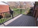 A wooden back deck features a black metal railing with views of the neighborhood beyond at 928 Hoover Village Dr # 928D, Indianapolis, IN 46260