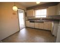 View of a kitchen with white cabinets, appliances, tile backsplash, and dining area at 928 Hoover Village Dr # 928D, Indianapolis, IN 46260