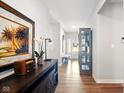 Inviting hallway with wood floors, console table and cabinet, leading to the front door at 9847 Bryce Blvd, Pendleton, IN 46064