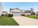 Well-maintained home with a spacious driveway, green lawn, and attached two-car garage at 10861 Tealpoint Dr, Indianapolis, IN 46229