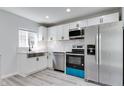 Modern kitchen featuring stainless steel appliances, white cabinetry and backsplash, plus a large stainless sink at 1125 N Colorado Ave, Indianapolis, IN 46201