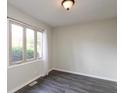 Bedroom with a gray wood-look floor, a large window, natural lighting, and neutral paint at 1131 Canterbury S Sq, Indianapolis, IN 46260