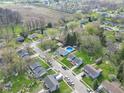 Residential neighborhood with mature trees, varied home styles, and visible swimming pool in backyard at 11423 Mutz Cir, Indianapolis, IN 46229