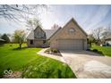 Lovely brick home showcasing an attached garage and well-manicured lawn, creating great curb appeal at 11525 Capistrano Cir, Indianapolis, IN 46236