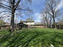 Spacious backyard showcasing a screened-in porch, lush lawn, and mature trees, perfect for outdoor enjoyment at 1235 Cottonwood Ct, Carmel, IN 46033