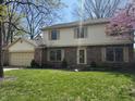 Inviting two-story home with a brick and vinyl exterior, a well-kept lawn, and flowering trees at 1235 Cottonwood Ct, Carmel, IN 46033