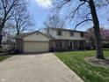 Traditional two-story home boasting a brick facade, attached garage, and lush green lawn at 1235 Cottonwood Ct, Carmel, IN 46033