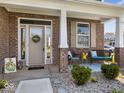 Inviting front porch with seating, a wreath on the door, and beautiful brickwork at 1305 Bontrager Ln, Shelbyville, IN 46176