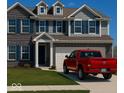 Charming two-story home featuring brick and gray siding, complemented by blue shutters and a well-maintained lawn at 1573 Vera Blvd, Danville, IN 46122