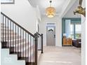 Bright foyer with staircase, light hardwood floors, and modern light fixture at 1614 Waterleaf Dr, Westfield, IN 46074