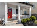Inviting front porch with a red door, house number, and manicured bushes at 1614 Waterleaf Dr, Westfield, IN 46074