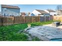 Spacious backyard featuring well-maintained grass, a stone patio, and a wood fence at 1696 Carlton Dr, Greenfield, IN 46140