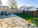 Backyard with stone patio, wood fence, and patio furniture under a pergola at 1696 Carlton Dr, Greenfield, IN 46140