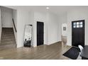 Spacious foyer with a staircase, large mirror, black accent doors, and wood-look vinyl floors at 1818 Orleans St, Indianapolis, IN 46203
