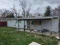 Backyard view of home featuring a covered patio, white siding and shuttered windows at 1830 S Chester Ave, Indianapolis, IN 46203