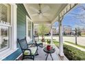 Inviting front porch with comfortable seating, decorative plants, and a ceiling fan for a relaxing outdoor experience at 2197 Duke Of York St, Carmel, IN 46032