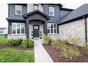 Close-up of the entryway and front door with stone accents and professional landscaping at 2280 Meadow Crk, Avon, IN 46123