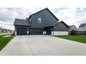 Three-car garage and driveway with siding exterior at 2280 Meadow Crk, Avon, IN 46123