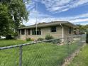 Property with chain link fence, stone exterior, and manicured lawn at 3315 Hillcrest Dr, Columbus, IN 47203