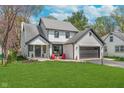 Charming two-story home with a landscaped front yard and an attached two-car garage, painted in white with black accents at 333 S Fourth St, Zionsville, IN 46077