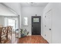 Bright foyer featuring hardwood floors, white walls, a black front door, and views into the dining room at 333 S Fourth St, Zionsville, IN 46077
