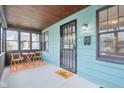 Inviting enclosed front porch with wood ceiling, charming rug, seating and plenty of natural light at 3433 Brouse Ave, Indianapolis, IN 46218
