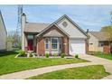 Well-maintained home featuring brick accents, a bay window, and lush landscaping at 376 Lake Ridge Ln, Greenwood, IN 46142
