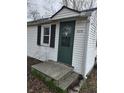 Inviting front entrance featuring a painted front door, white siding, and well-kept concrete steps at 4210 E Naomi St, Indianapolis, IN 46203