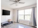 Bright bedroom with ceiling fan, large window with curtains, and hardwood floors at 5820 Marble Ct, Anderson, IN 46013