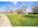 Two-story home on a well-maintained lawn with an attached garage and a sunny, blue sky at 5820 Marble Ct, Anderson, IN 46013