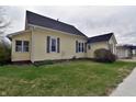 An inviting yellow home with a side view showcasing its classic design and yard space at 609 E Columbus St, Martinsville, IN 46151