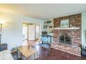Well-lit living room showcasing a cozy brick fireplace and hardwood floors, creating a welcoming atmosphere at 6133 Buttonwood Dr, Noblesville, IN 46062