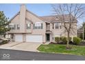 Two-story home featuring a two-car garage, neutral siding and trim, a well maintained lawn, and manicured bushes at 6259 Bishops Pond Ln, Indianapolis, IN 46268