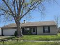 Charming one-story home with attached two-car garage and well-maintained lawn, shaded by a mature tree at 6611 Kellum Dr, Indianapolis, IN 46221