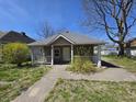 Cozy home featuring a welcoming front porch, complemented by a lawn with small yellow flowers at 716 Lynn St, Indianapolis, IN 46222