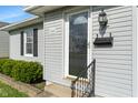 Close-up of the front entrance featuring a stylish door, modern lighting, and green landscaping at 844 Blanchard St, Shelbyville, IN 46176
