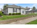 A quaint home with manicured lawn, brick foundation, and neutral siding at 844 Blanchard St, Shelbyville, IN 46176
