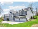 Well-manicured lawn of a luxurious, two-story home with a three-car garage and a charming exterior design at 961 Starkey Rd, Zionsville, IN 46077