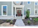 Inviting front entrance with a stylish wood door, decorative wreath, and well-maintained landscaping at 961 Starkey Rd, Zionsville, IN 46077