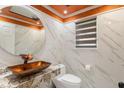 Stylish powder room features marble walls and modern sink with bronze accents at 9664 Trail Dr, Avon, IN 46123