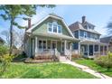 Charming home with a welcoming front porch, lush landscaping, and a freshly painted exterior at 1217 Evison St, Indianapolis, IN 46203